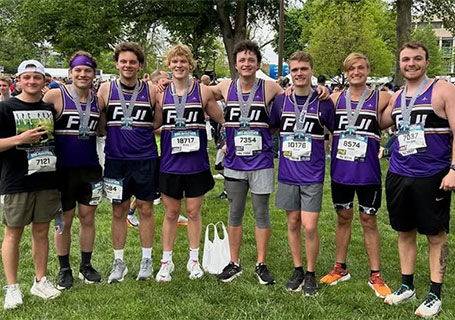 Members of the Phi Gamma Delta fraternity pose wearing their purple colors. 